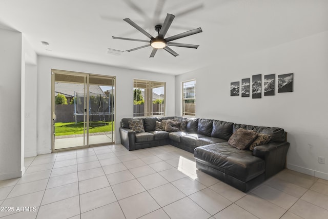 living area with light tile patterned floors, visible vents, baseboards, and ceiling fan