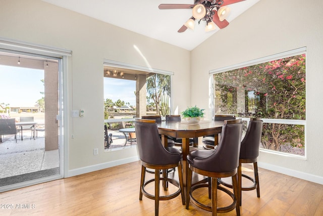 dining room featuring ceiling fan, light hardwood / wood-style floors, and vaulted ceiling