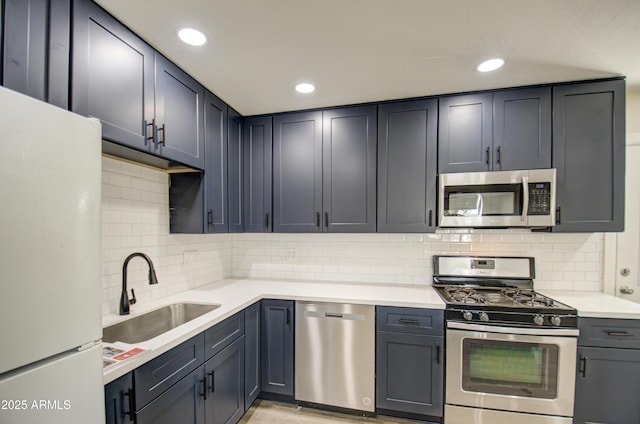 kitchen featuring backsplash, sink, and appliances with stainless steel finishes