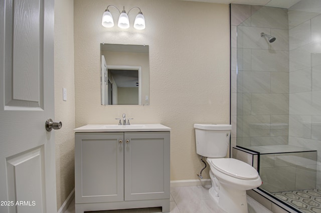 bathroom featuring tiled shower, tile patterned flooring, vanity, and toilet