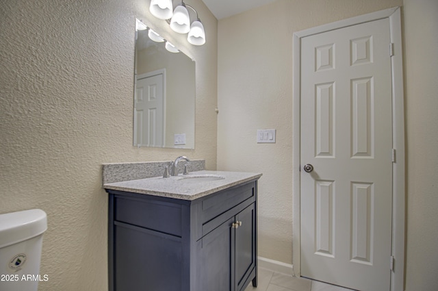 bathroom featuring tile patterned flooring, vanity, and toilet