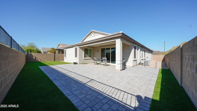 rear view of property with central AC, a patio area, and a yard