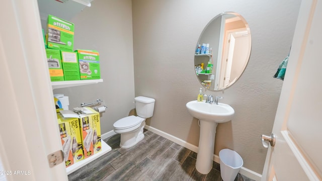 bathroom featuring toilet, sink, and hardwood / wood-style floors