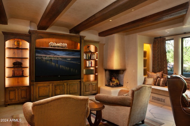 cinema room featuring beamed ceiling, built in shelves, and light tile patterned flooring