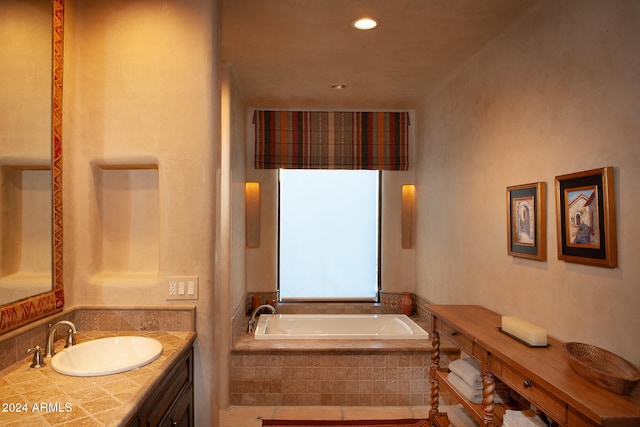 bathroom with vanity and a relaxing tiled tub