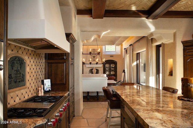 kitchen with a notable chandelier, a kitchen bar, premium range hood, and stainless steel stove