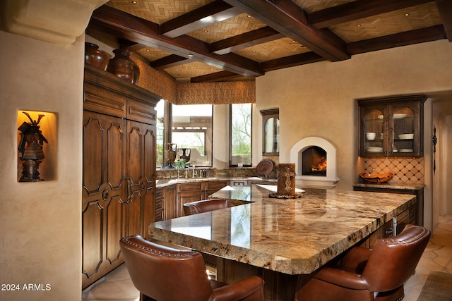 dining area with beam ceiling, sink, light tile patterned floors, and coffered ceiling