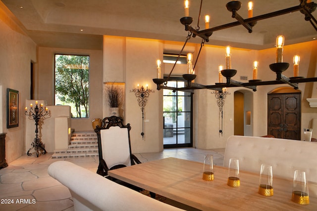 tiled dining room featuring a raised ceiling and a high ceiling