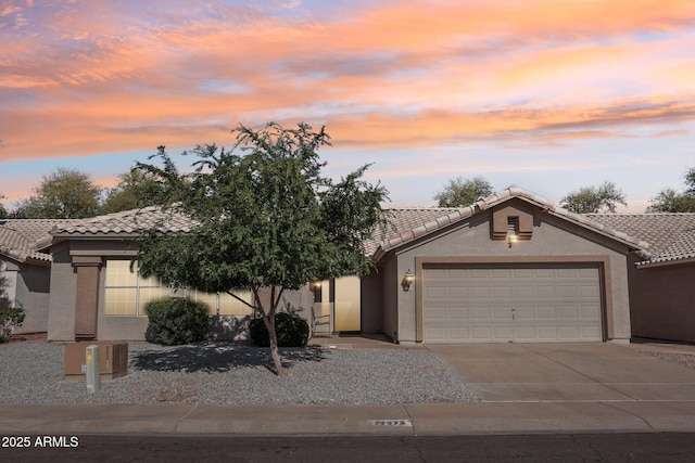 view of front of house with a garage, stucco siding, and a tile roof