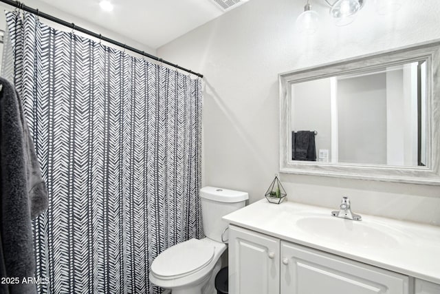 bathroom featuring toilet, vanity, and a shower with curtain
