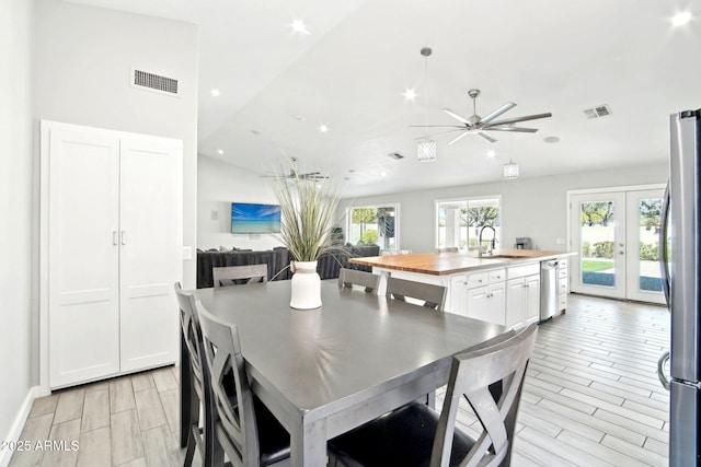 dining room with visible vents, wood tiled floor, french doors, and ceiling fan