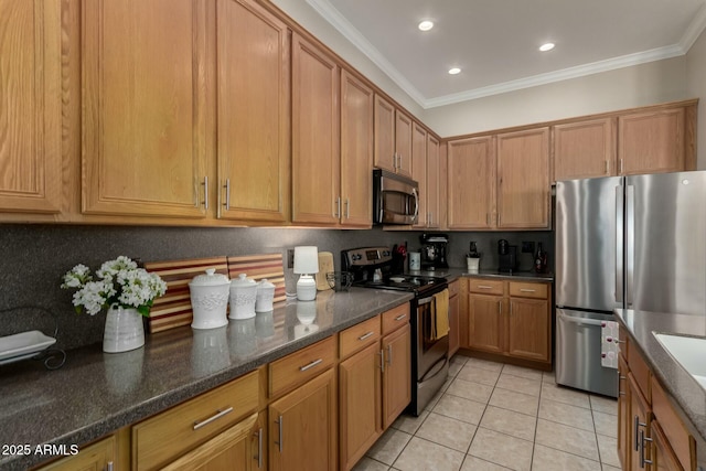 kitchen featuring crown molding, light tile patterned flooring, dark stone counters, and appliances with stainless steel finishes