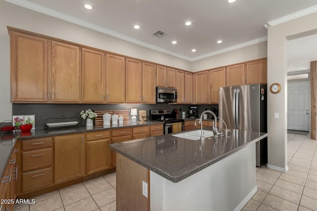 kitchen featuring sink, light tile patterned floors, stainless steel appliances, and an island with sink