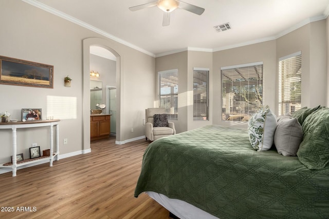 bedroom with multiple windows, connected bathroom, crown molding, and light hardwood / wood-style flooring