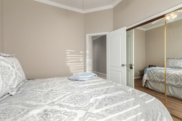 bedroom featuring crown molding, wood-type flooring, and a closet