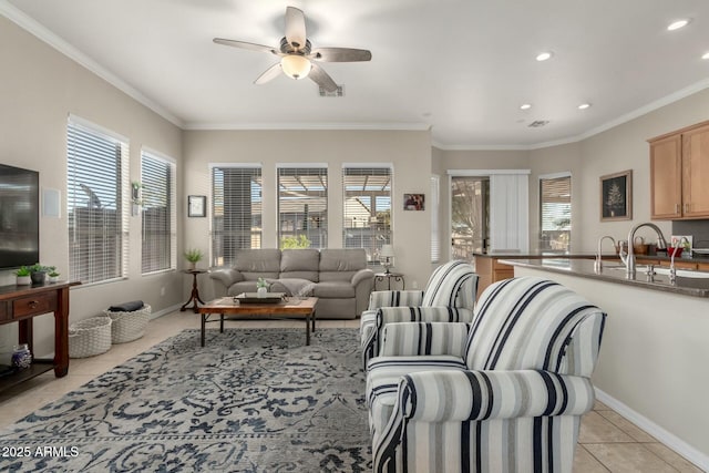 tiled living room featuring sink, ornamental molding, a healthy amount of sunlight, and ceiling fan