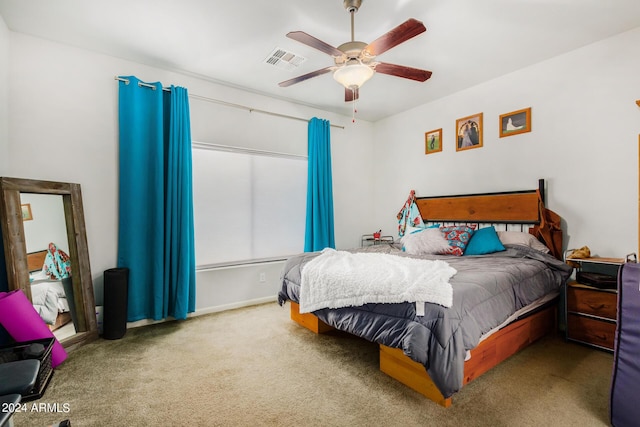 carpeted bedroom featuring a ceiling fan and visible vents