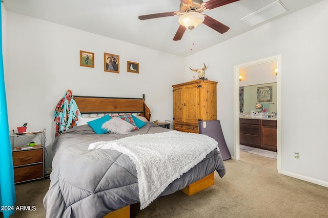 bedroom featuring visible vents, ensuite bathroom, a ceiling fan, baseboards, and light colored carpet