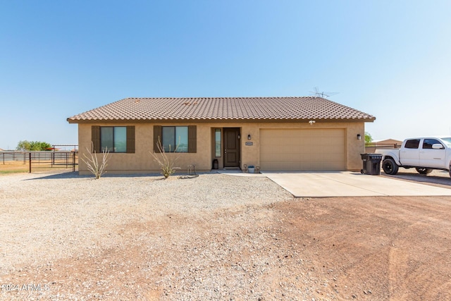 ranch-style home with fence, a tile roof, concrete driveway, stucco siding, and an attached garage