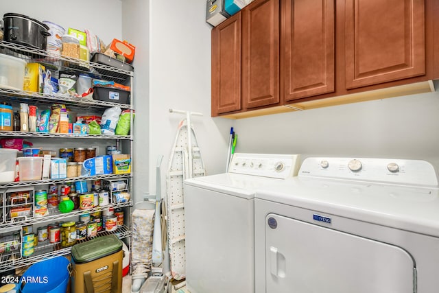 washroom featuring separate washer and dryer and cabinets