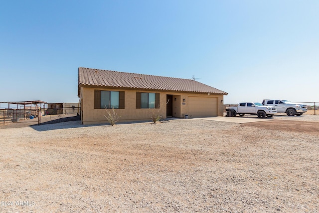 ranch-style house with fence, an attached garage, stucco siding, concrete driveway, and a tiled roof