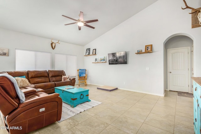 living room featuring baseboards, arched walkways, high vaulted ceiling, and ceiling fan