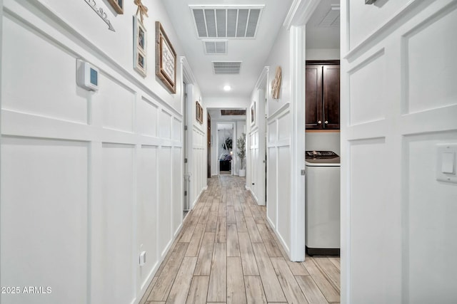 hallway featuring light hardwood / wood-style floors and washer / clothes dryer