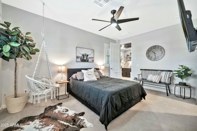 bedroom featuring ceiling fan, light colored carpet, and connected bathroom