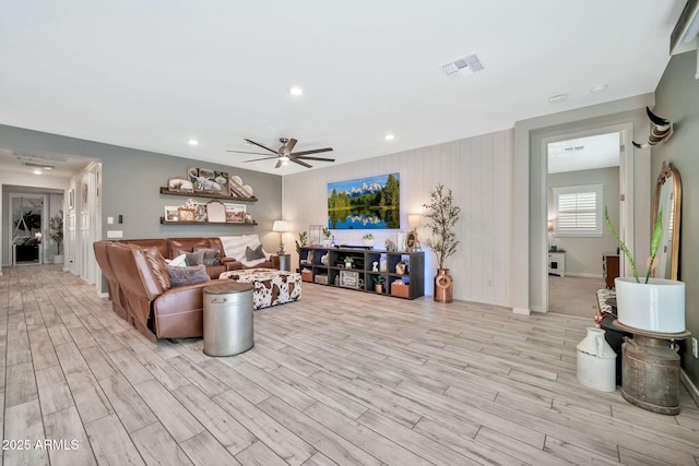 living room with ceiling fan and light hardwood / wood-style flooring