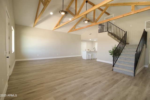 2573 E Superstition Blvd, Apache Junction, AZ 85119 - unfurnished living room with high vaulted ceiling, beam ceiling, stairs, baseboards, and a sink