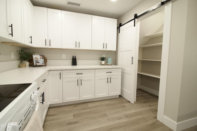 2573 E Superstition Blvd, Apache Junction, AZ 85119 - kitchen featuring white electric range oven, a barn door, white cabinetry, and light wood finished floors