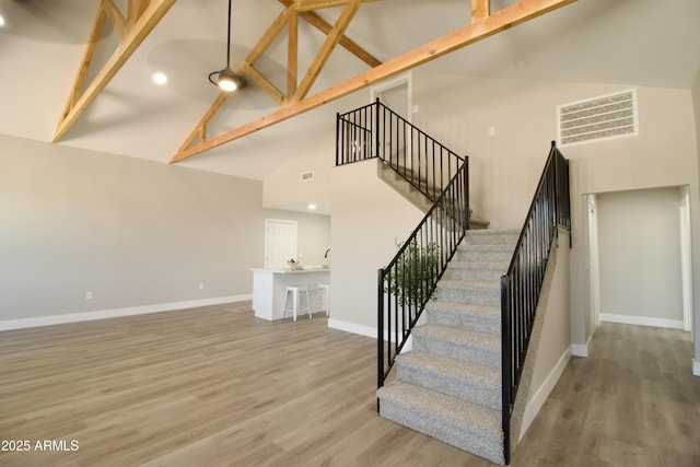 2573 E Superstition Blvd, Apache Junction, AZ 85119 - stairs with high vaulted ceiling, baseboards, wood finished floors, and beam ceiling