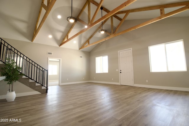 2573 E Superstition Blvd, Apache Junction, AZ 85119 - unfurnished living room with high vaulted ceiling, beam ceiling, baseboards, stairs, and wood finished floors