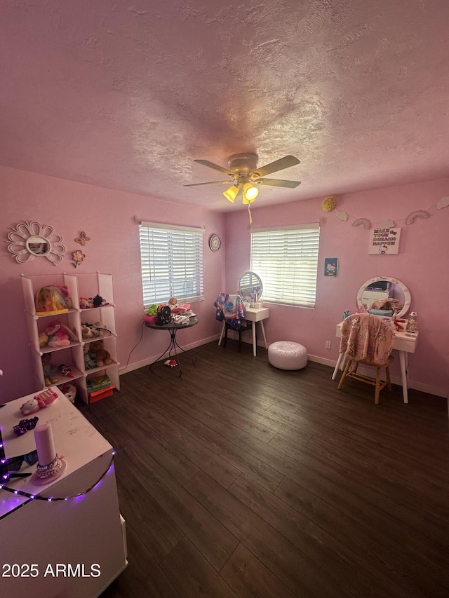 game room featuring a textured ceiling, wood finished floors, a ceiling fan, and baseboards