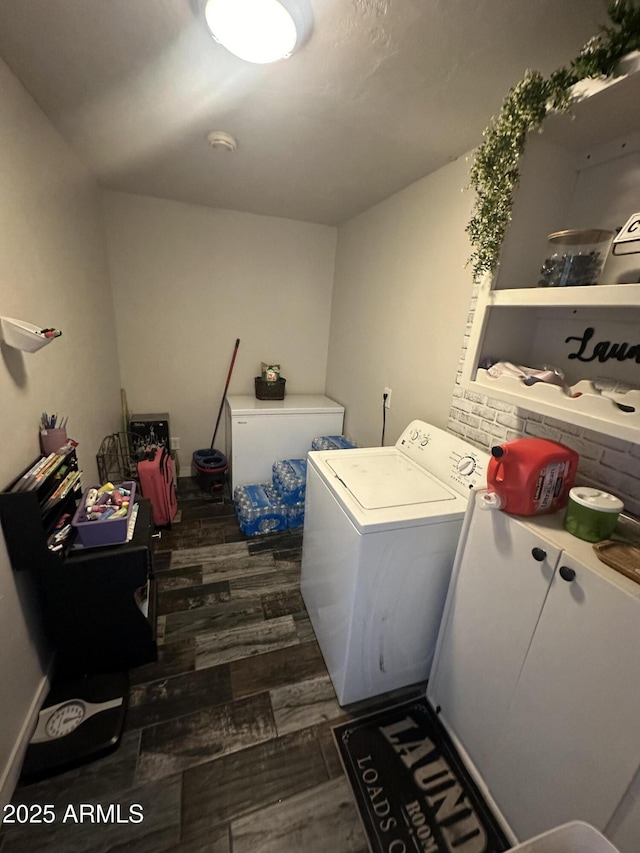 washroom with dark wood-style floors, washing machine and dryer, and laundry area