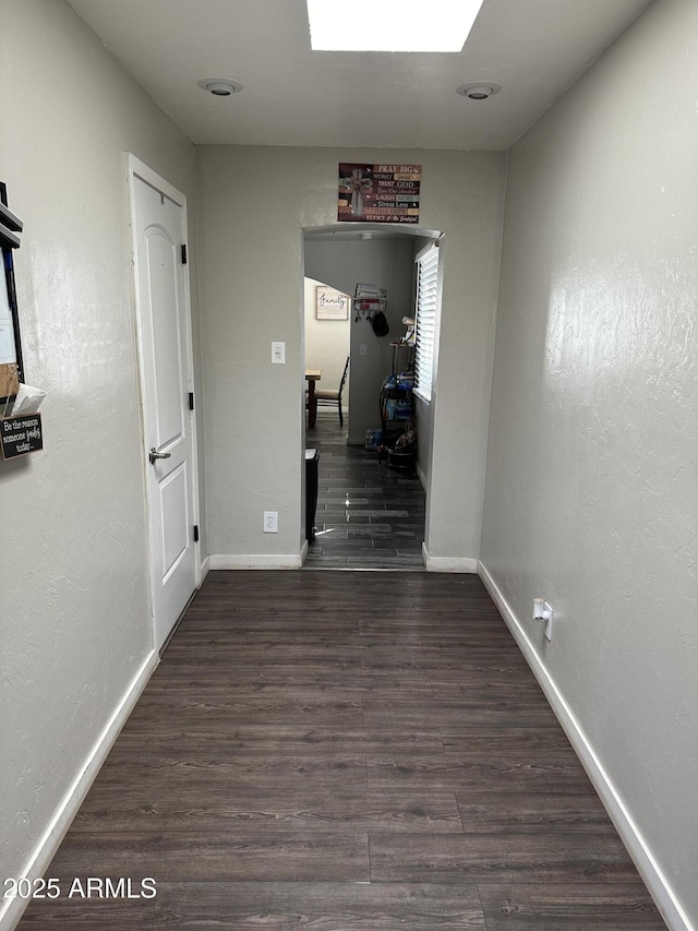 hallway with baseboards and wood finished floors