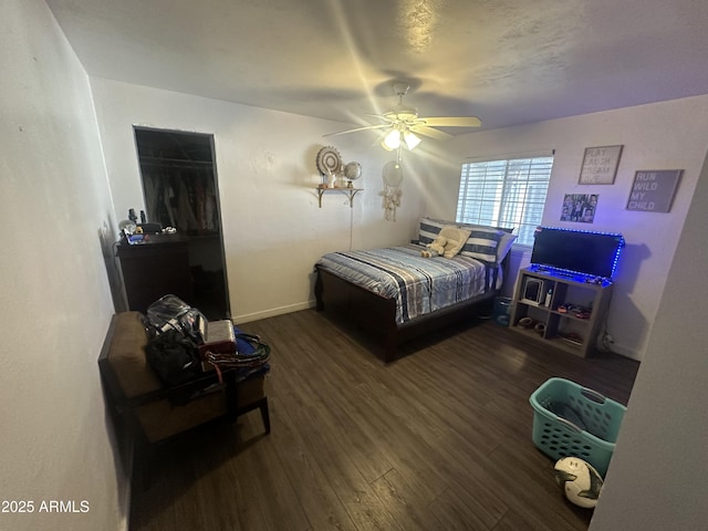 bedroom featuring a ceiling fan, baseboards, and wood finished floors