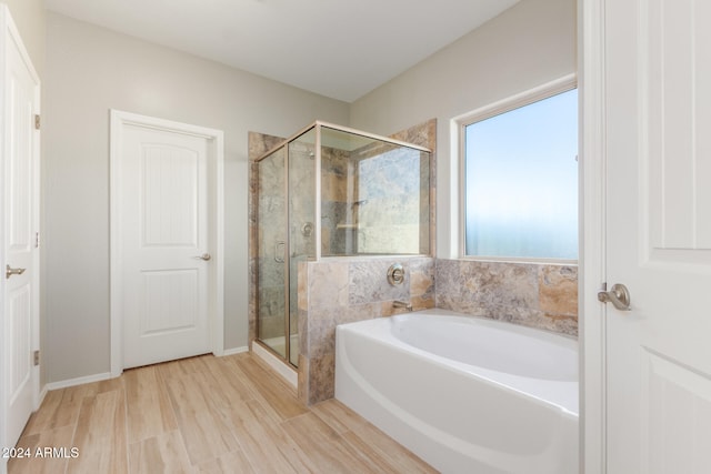 bathroom with hardwood / wood-style floors and shower with separate bathtub