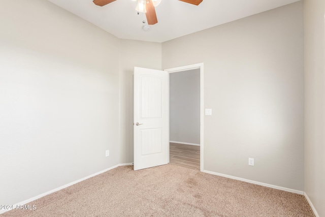 empty room featuring ceiling fan and carpet