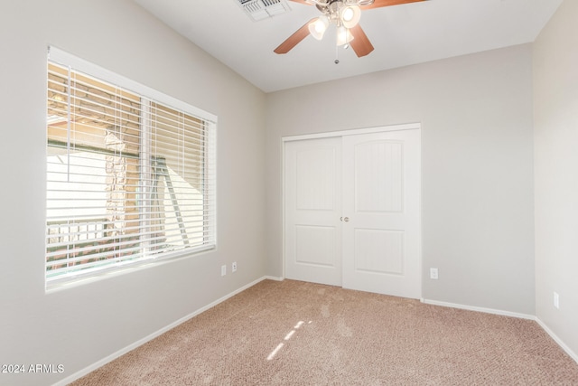 unfurnished bedroom with carpet flooring, ceiling fan, and a closet