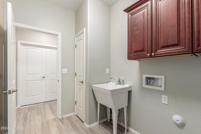 washroom featuring cabinets, washer hookup, and light wood-type flooring