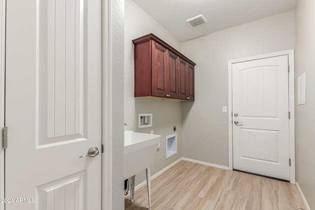 washroom featuring electric dryer hookup, cabinets, sink, light hardwood / wood-style flooring, and washer hookup