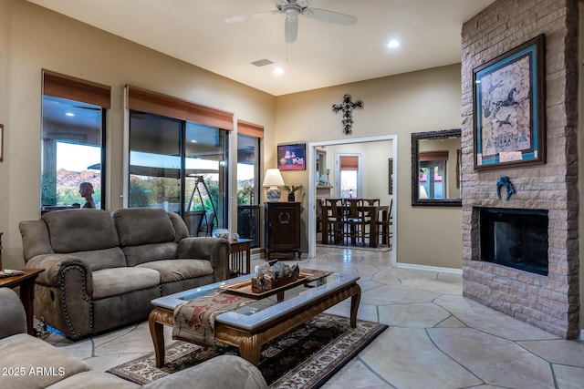 living room with ceiling fan, a brick fireplace, and plenty of natural light