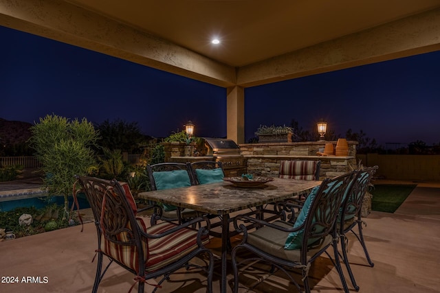 patio at night with area for grilling and exterior kitchen