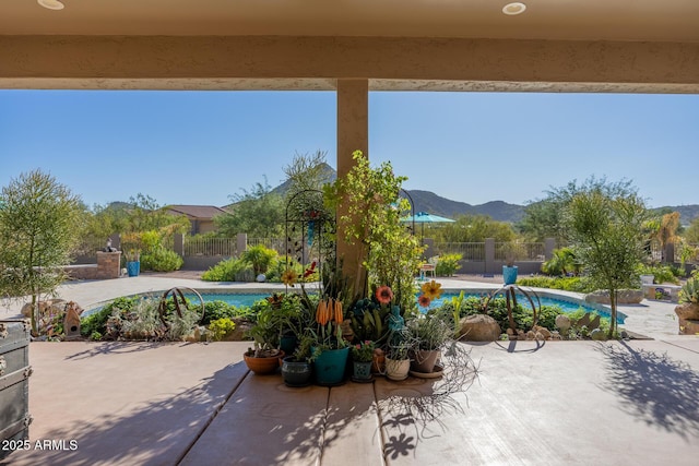 view of patio featuring a fenced in pool and a mountain view