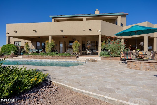 view of swimming pool with ceiling fan and a patio area