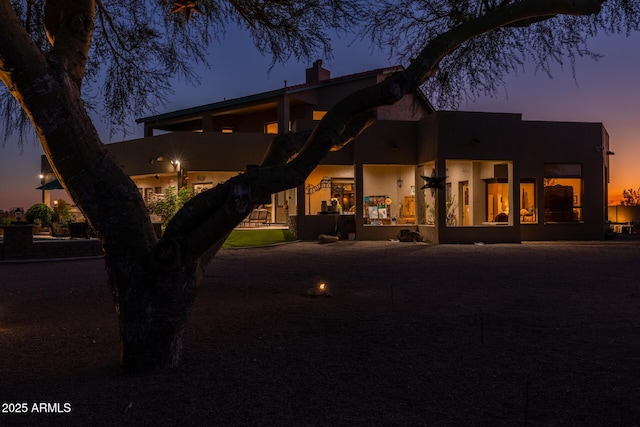 view of back house at dusk