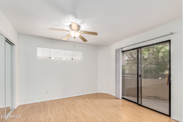 unfurnished room with a textured ceiling, light hardwood / wood-style floors, and ceiling fan