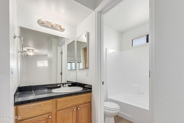 full bathroom featuring ceiling fan, vanity, a healthy amount of sunlight, and toilet