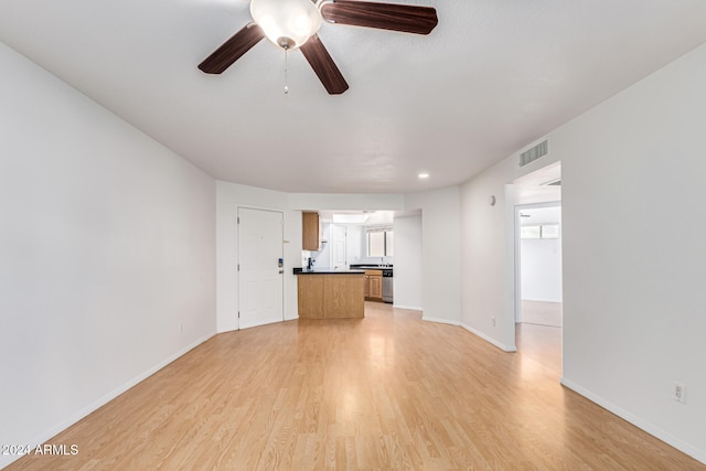 unfurnished living room with ceiling fan and light hardwood / wood-style flooring